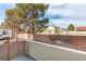 Small, private backyard with a gate and partial view of neighboring buildings at 6860 Coral Rock Dr, Las Vegas, NV 89108