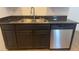 Dark wood cabinets, granite countertops, and stainless steel dishwasher at 690 Calamus Palm Pl, Henderson, NV 89011