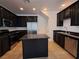 Modern kitchen with island, stainless steel appliances, and dark cabinets at 690 Calamus Palm Pl, Henderson, NV 89011