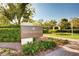 Entrance sign for 'The Promenade' with vibrant flowers and manicured landscaping at 7129 Flora Lam St, Las Vegas, NV 89166