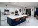 Well-lit kitchen featuring a navy blue island, stainless steel appliances, and a dining area at 7129 Flora Lam St, Las Vegas, NV 89166