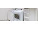 Bright laundry area with a full-sized washer, dryer and storage shelves at 7129 Flora Lam St, Las Vegas, NV 89166