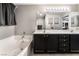 Bathroom with double sinks, dark cabinets, and a soaking tub at 7879 Narnia Ave, Las Vegas, NV 89113