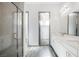 Modern bathroom with double vanity, glass shower, and gray tile floor at 816 Loch Katrine Ave, Henderson, NV 89012