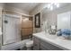 Clean bathroom with gray vanity, shower, and bathtub at 8233 Ducharme Ave, Las Vegas, NV 89145