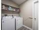 Bright laundry room, featuring washer, dryer, and shelving at 8233 Ducharme Ave, Las Vegas, NV 89145