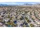 Aerial perspective of a residential neighborhood, highlighting houses with pools and mountain views at 9225 Evergreen Canyon Dr, Las Vegas, NV 89134