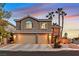 Two-story home with three-car garage, lit at dusk at 9225 Evergreen Canyon Dr, Las Vegas, NV 89134