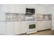 Bright kitchen featuring white cabinets, granite countertops, and a tile backsplash at 9757 Marcelline Ave, Las Vegas, NV 89148