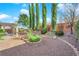 Spacious backyard featuring a pergola, manicured landscaping, and privacy trees at 10125 James Harbin Ave, Las Vegas, NV 89129