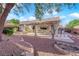 Backyard with a covered patio, landscaped yard and desert style vegetation at 10125 James Harbin Ave, Las Vegas, NV 89129