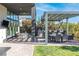 Outdoor space with covered patio, outdoor kitchen, grill, bar seating, lounge chairs, and dining table on a sunny day at 11015 Sanctuary Cove Ct, Las Vegas, NV 89135