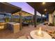 Backyard patio with an outdoor kitchen, comfortable seating, and a cozy gas fire pit at 11015 Sanctuary Cove Ct, Las Vegas, NV 89135