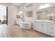 Elegant bathroom with a freestanding tub, double vanities, and a view into the main bedroom showcasing modern design at 11015 Sanctuary Cove Ct, Las Vegas, NV 89135