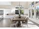 Bright dining room with a long wooden table, seating for ten, and large windows offering plenty of natural light at 11015 Sanctuary Cove Ct, Las Vegas, NV 89135