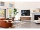 Comfortable living room with fireplace, modern decor, and large windows at 11015 Sanctuary Cove Ct, Las Vegas, NV 89135