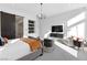 Bright main bedroom featuring modern chandelier, TV, built-in shelving, and a barn door leading to the bathroom at 11015 Sanctuary Cove Ct, Las Vegas, NV 89135