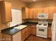 Kitchen with wood cabinets, white appliances, and double sink at 8708 Gateway Glen Dr, Las Vegas, NV 89178