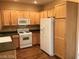 Kitchen with wood cabinets, white appliances, and dark countertop at 8708 Gateway Glen Dr, Las Vegas, NV 89178