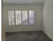 Bright bedroom with grey carpet and large window with shutters at 10321 Junction Hill Dr, Las Vegas, NV 89134