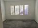 Spacious bedroom featuring grey carpet and large window with shutters at 10321 Junction Hill Dr, Las Vegas, NV 89134
