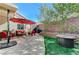 Landscaped backyard featuring a paved patio, outdoor seating, and an artificial grass area with a fire pit at 1595 Cattle Ranch Pl, Henderson, NV 89002
