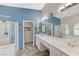 Primary bathroom featuring a double sink vanity, a glass shower, and marble floors at 1595 Cattle Ranch Pl, Henderson, NV 89002
