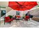 Cozy patio area with stylish red outdoor seating beneath a large shade umbrella at 1595 Cattle Ranch Pl, Henderson, NV 89002