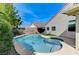 Backyard pool with jacuzzi and lounge chairs, surrounded by mature landscaping and a block wall fence at 1595 Cattle Ranch Pl, Henderson, NV 89002