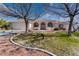 House exterior with a manicured lawn and mature trees at 2061 Iroquois Ave, Pahrump, NV 89048