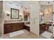An elegant bathroom with dual vanities, a soaking tub, tiled floors, and custom lighting at 22 Rue Grimaldi Way, Henderson, NV 89011
