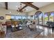 A bright living room featuring hardwood floors, high ceilings, exposed wood beams, and large windows at 22 Rue Grimaldi Way, Henderson, NV 89011