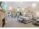 A luxurious main bedroom with a fireplace, sitting area, chandelier, and access to the outdoor space at 22 Rue Grimaldi Way, Henderson, NV 89011