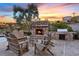 Cozy outdoor fireplace with a stone surround, built-in grill, and comfortable seating at 22 Rue Grimaldi Way, Henderson, NV 89011