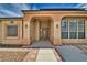 Tan house with a walkway leading to the entrance. It features a brown door and large windows at 2871 S Woodchips Rd, Pahrump, NV 89048