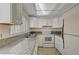 White kitchen with granite counters and view to backyard at 4770 Topaz St # 77, Las Vegas, NV 89121