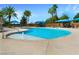 Relaxing community pool with palm trees and blue umbrellas at 4880 Da Vinci Way, Pahrump, NV 89061