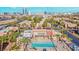 Scenic aerial view of the community with a pool, palm trees, and city skyline in background at 5493 Indian River Dr # 383, Las Vegas, NV 89103