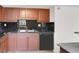 Kitchen showcasing a stainless steel sink, black backsplash, wood cabinets, and black dishwasher for modern living at 5493 Indian River Dr # 383, Las Vegas, NV 89103