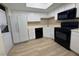 Bright kitchen with white cabinets, black appliances, and light flooring at 5905 Smoke Ranch Rd # A, Las Vegas, NV 89108
