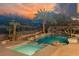 Inviting pool and spa with rock waterfall, slide, and lush tropical landscaping for a backyard oasis at 646 Saint Croix St, Henderson, NV 89012
