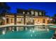 Stunning home exterior with a sparkling pool, fire pit, and covered patio with stone columns at 646 Saint Croix St, Henderson, NV 89012