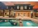 Stunning home exterior with a sparkling pool, fire pit, and covered patio with stone columns at 646 Saint Croix St, Henderson, NV 89012