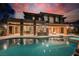 Stunning home exterior with a sparkling pool, fire pit, and covered patio with stone columns at 646 Saint Croix St, Henderson, NV 89012