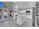 Modern kitchen with island, white cabinets, and stainless steel appliances at 6586 W Mesa Vista Ave, Las Vegas, NV 89118