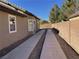 Side yard with long concrete driveway and block wall at 7405 Chorleywood Way, Las Vegas, NV 89131