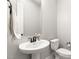 Clean and modern bathroom with pedestal sink, toilet, and mirror at 8575 Nicholas James Ave, Las Vegas, NV 89143