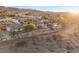 Elevated view of a desert home with retaining walls, mature trees, and mountain views at sunset at 942 Villa Grande Way, Boulder City, NV 89005