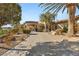 Elegant home with a circular driveway, lush landscaping, and a welcoming entrance at 942 Villa Grande Way, Boulder City, NV 89005