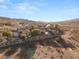 Scenic shot of a hillside home with a retaining wall, desert landscaping, and mountain views at 942 Villa Grande Way, Boulder City, NV 89005
